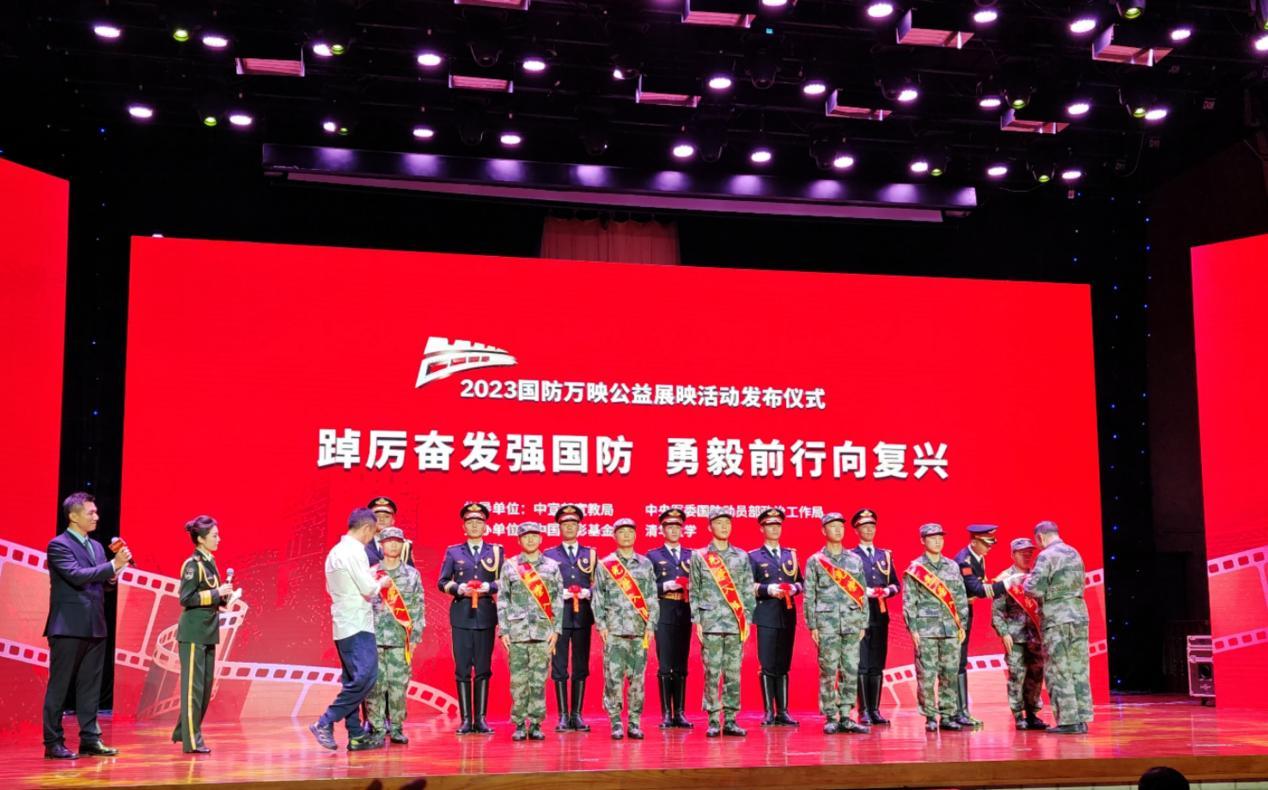 国防大学教授徐焰和演员侯勇为7名即将入伍的清华大学同学佩戴大红花。